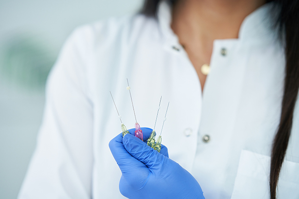 Beautician holding polydioxanone thread for lifting over light background